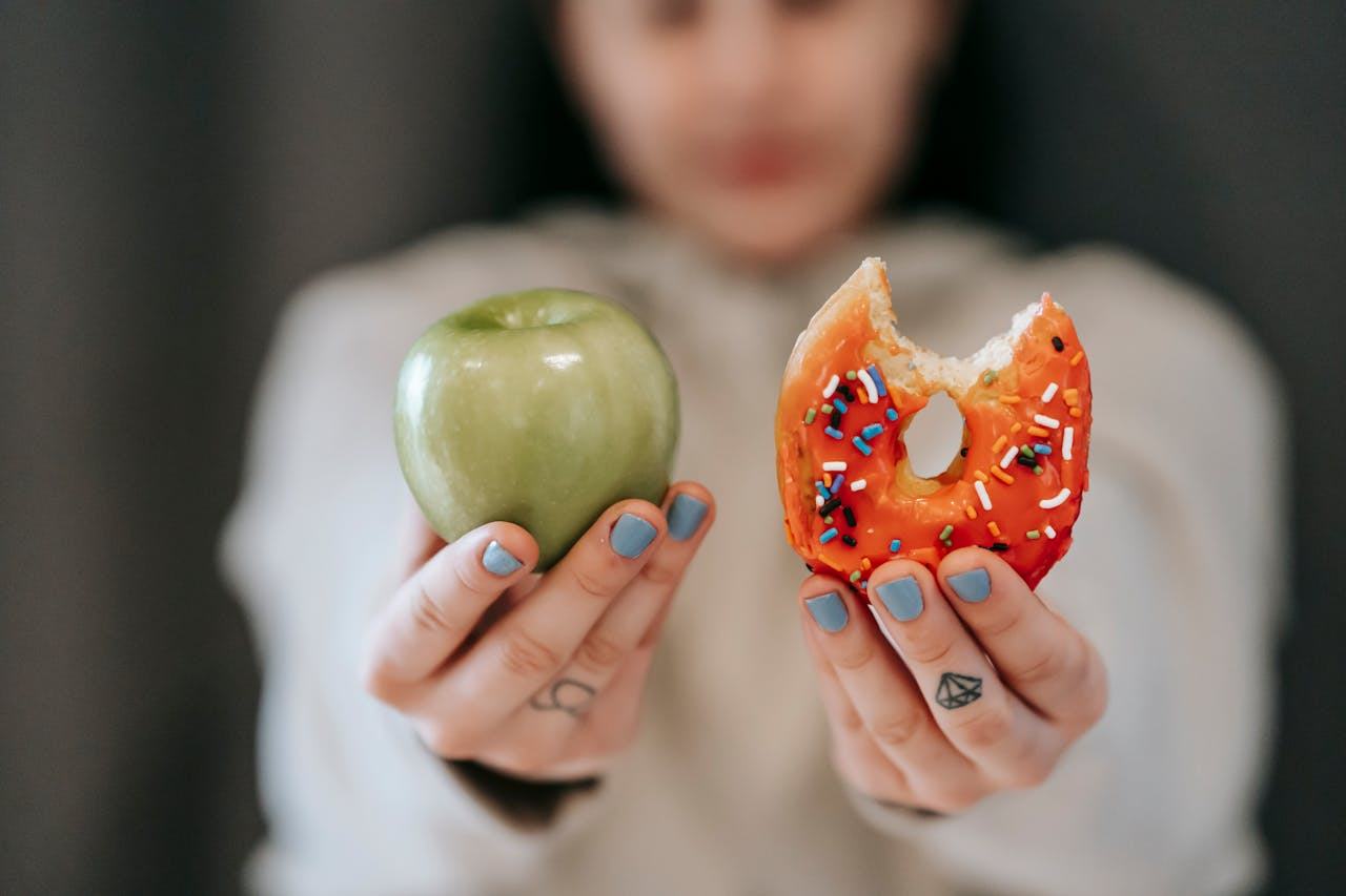 42-mujer sosteniendo una manzana y una dona